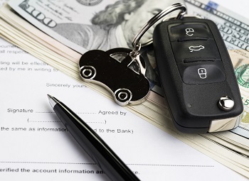 a set of car keys on top of a stack of cash
